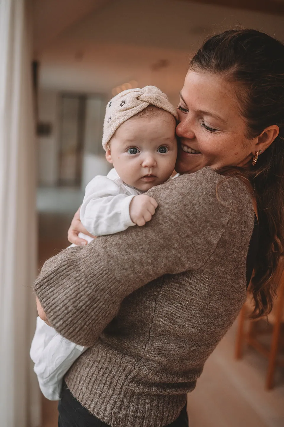 Mama knuffelt haar baby tegen haar wang